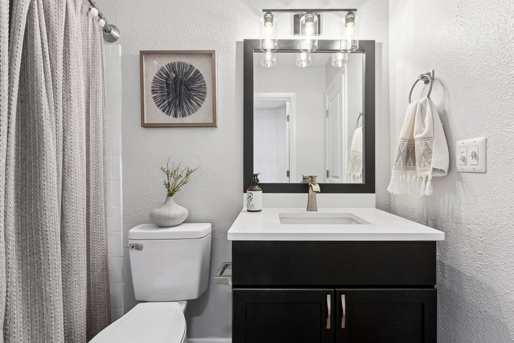 Bathroom A bathroom with a white toilet, a sink, a mirror, and a plant at Elme Druid Hills, Atlanta, Georgia